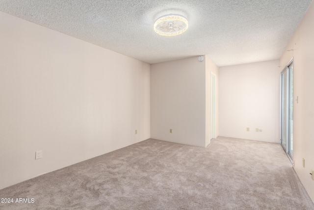 carpeted empty room with a textured ceiling