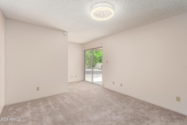 empty room with carpet and a textured ceiling