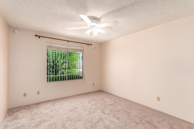 carpeted spare room featuring a textured ceiling and a ceiling fan