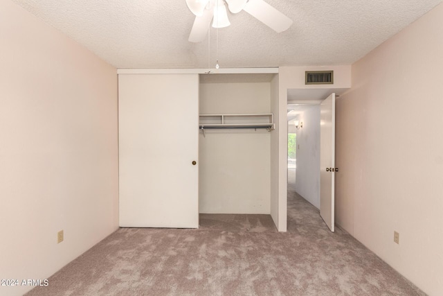 unfurnished bedroom with visible vents, a closet, carpet flooring, and a textured ceiling