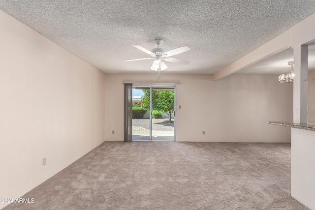 unfurnished room featuring a textured ceiling, carpet, and ceiling fan with notable chandelier
