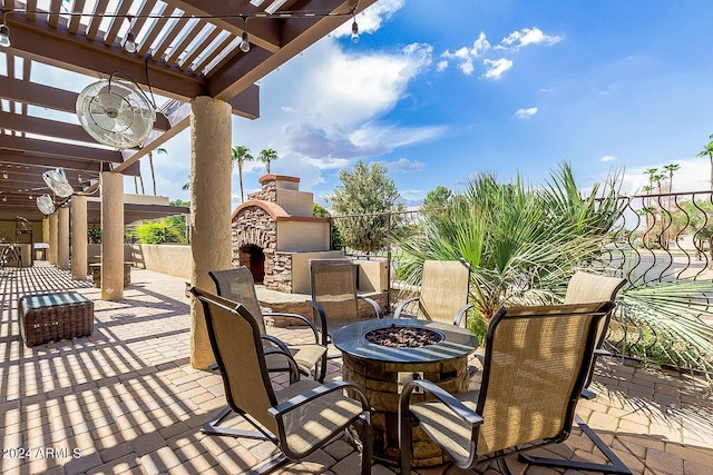 view of patio / terrace with a fire pit, exterior fireplace, and a pergola