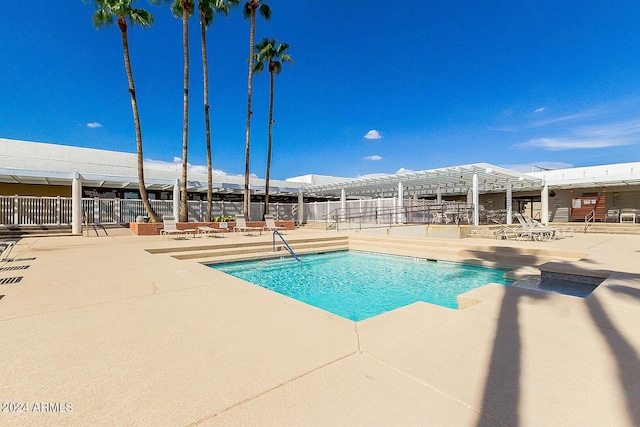 pool with a patio area, fence, and a pergola