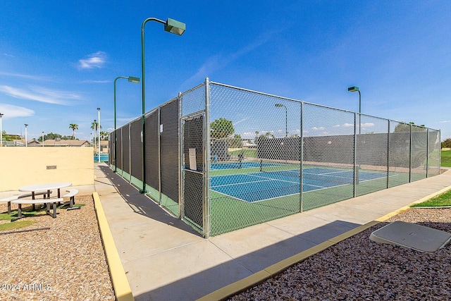 view of tennis court featuring fence