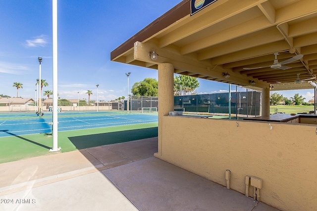view of home's community featuring a tennis court and fence
