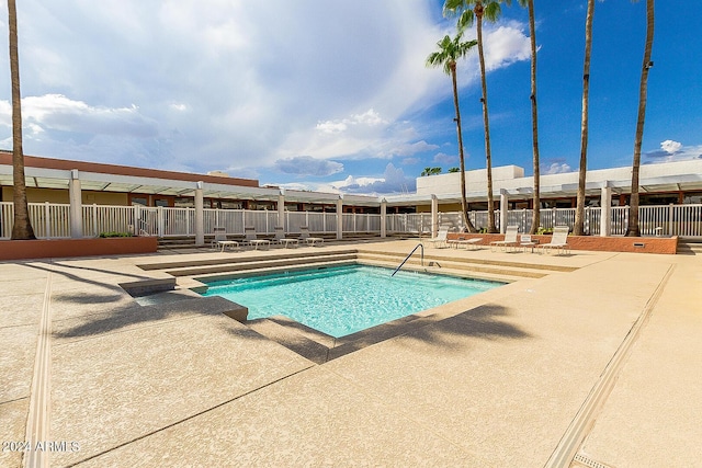 community pool with fence and a patio area
