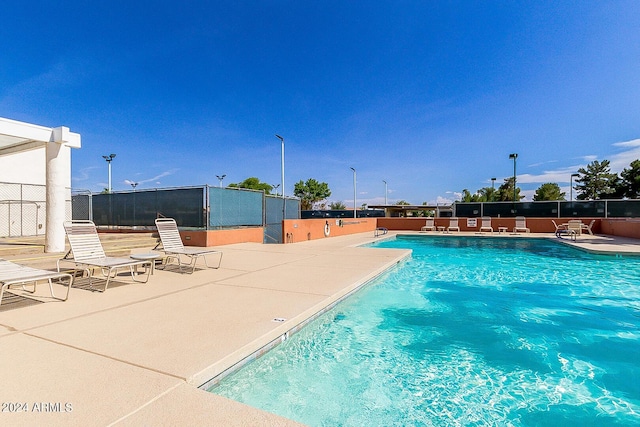 pool with a patio area and fence