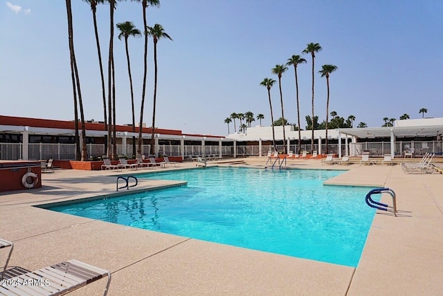 pool featuring fence and a patio area