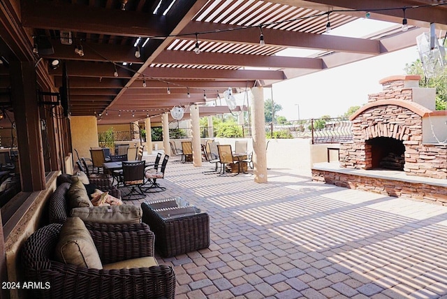 view of patio / terrace featuring a pergola, outdoor dining area, an outdoor stone fireplace, and fence