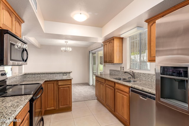 kitchen with light tile patterned flooring, appliances with stainless steel finishes, a sink, an inviting chandelier, and brown cabinetry