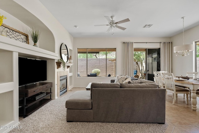 3026 W Silver Fox Way, Phoenix, AZ 85045 - living room with a chandelier, a fireplace, a ceiling fan, and tile patterned floors