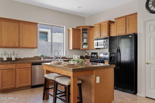 3026 W Silver Fox Way, Phoenix, AZ 85045 - kitchen featuring appliances with stainless steel finishes, a kitchen island, light tile patterned floors, a kitchen bar, and glass insert cabinets