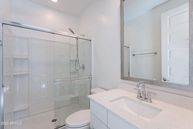 bathroom with a stall shower, vanity, and toilet