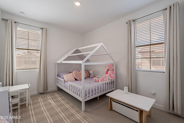 bedroom featuring carpet, multiple windows, and baseboards