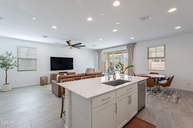 kitchen with light countertops, visible vents, a sink, and stainless steel dishwasher