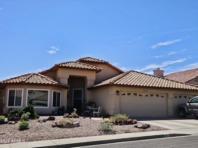2919 E Friess Dr E, Phoenix, AZ 85032 - mediterranean / spanish home with an attached garage, driveway, a tiled roof, and stucco siding