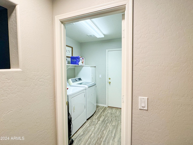 laundry room featuring light hardwood / wood-style flooring and washer and clothes dryer