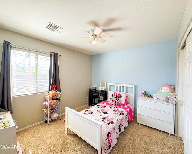 carpeted bedroom featuring a closet, a textured ceiling, and ceiling fan