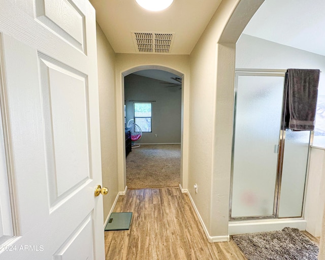 corridor featuring light hardwood / wood-style flooring and vaulted ceiling