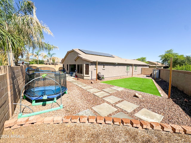 rear view of house with a trampoline