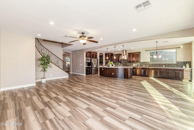 unfurnished living room with ceiling fan and light hardwood / wood-style floors