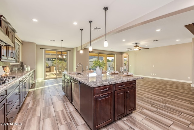 kitchen featuring ceiling fan, stainless steel appliances, an island with sink, pendant lighting, and light hardwood / wood-style floors