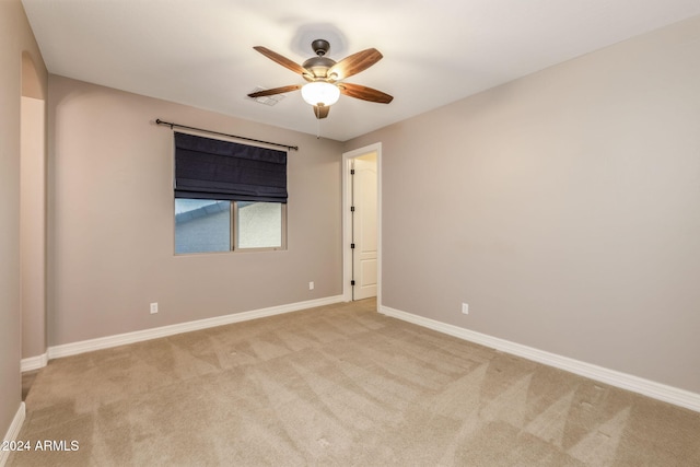 spare room with light colored carpet and ceiling fan