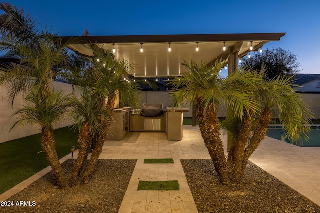 patio terrace at dusk featuring exterior kitchen