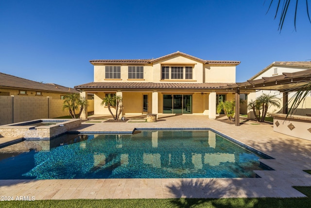 rear view of property with a pool with hot tub and a patio