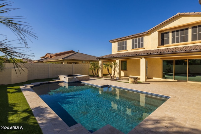 view of swimming pool featuring a patio area and an in ground hot tub