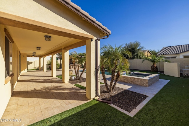 view of patio / terrace with ceiling fan and a swimming pool with hot tub