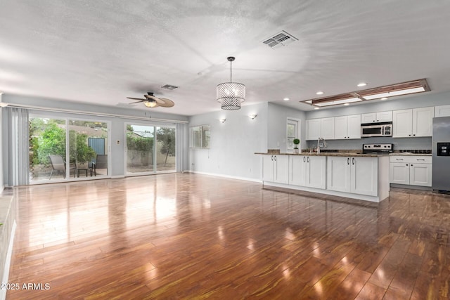 100 E Geneva Dr, Tempe, AZ 85282 - kitchen with appliances with stainless steel finishes, open floor plan, a sink, a peninsula, and hardwood / wood-style flooring