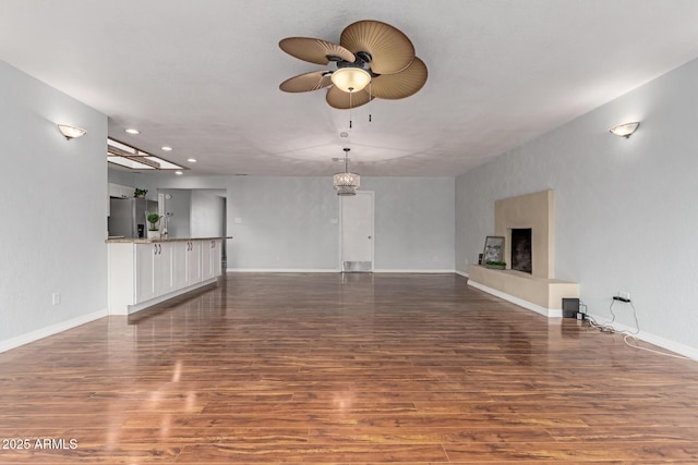 100 E Geneva Dr, Tempe, AZ 85282 - unfurnished living room with wood finished floors, a ceiling fan, baseboards, a fireplace with raised hearth, and recessed lighting
