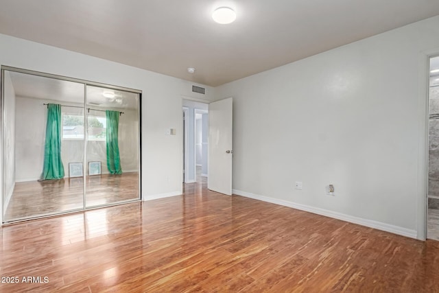 100 E Geneva Dr, Tempe, AZ 85282 - unfurnished bedroom with wood finished floors, baseboards, and a closet