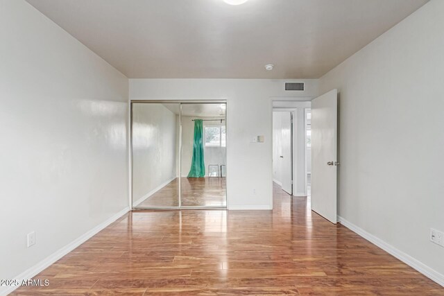 100 E Geneva Dr, Tempe, AZ 85282 - unfurnished bedroom featuring wood finished floors, a closet, and baseboards