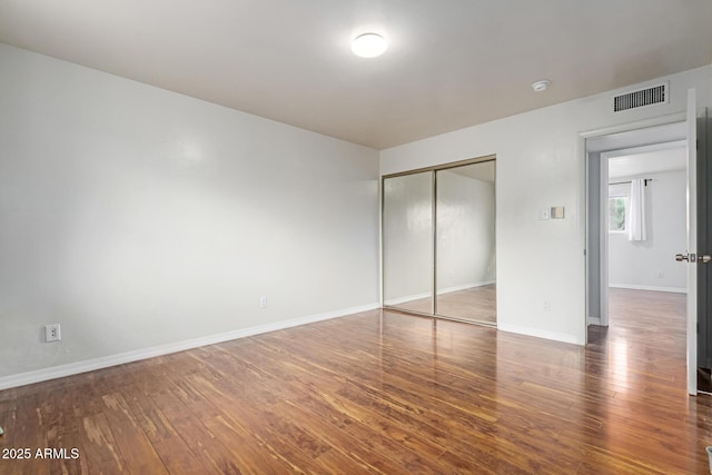 100 E Geneva Dr, Tempe, AZ 85282 - unfurnished bedroom featuring wood finished floors, a closet, and baseboards
