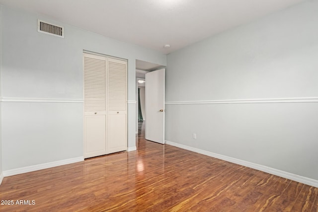 100 E Geneva Dr, Tempe, AZ 85282 - unfurnished bedroom with wood finished floors, a closet, and baseboards