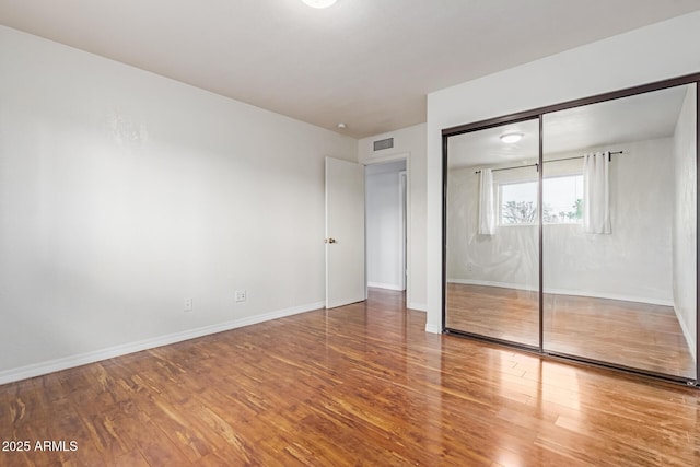 100 E Geneva Dr, Tempe, AZ 85282 - unfurnished bedroom featuring wood finished floors, baseboards, and a closet
