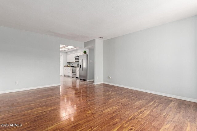 100 E Geneva Dr, Tempe, AZ 85282 - unfurnished living room with wood finished floors and baseboards