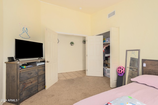 bedroom featuring light carpet and a closet