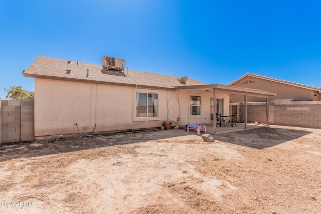 rear view of property with central air condition unit and a patio