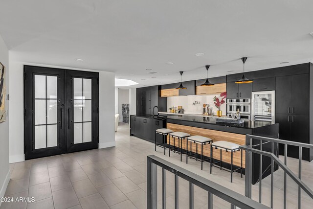 3800 E Lincoln Dr Unit 42, Phoenix, AZ 85018 - kitchen with dark cabinetry, french doors, modern cabinets, baseboards, and recessed lighting
