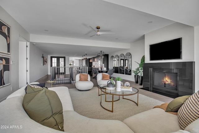 3800 E Lincoln Dr Unit 42, Phoenix, AZ 85018 - living area with wood finished floors, a fireplace with flush hearth, a ceiling fan, and baseboards
