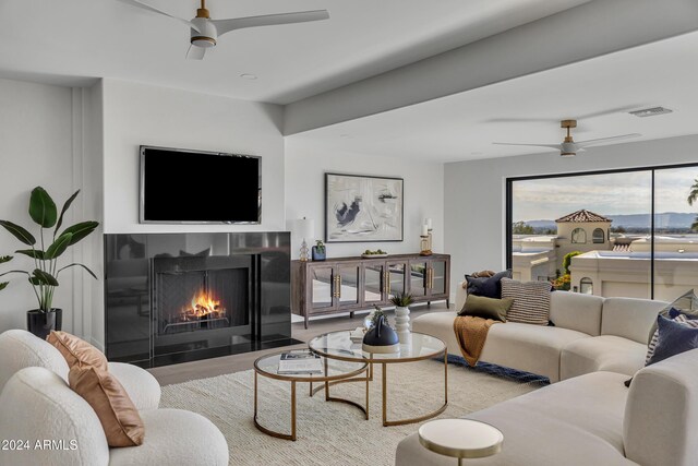 3800 E Lincoln Dr Unit 42, Phoenix, AZ 85018 - living area with ceiling fan, a fireplace with flush hearth, and wood finished floors