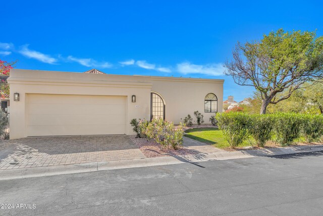 3800 E Lincoln Dr Unit 42, Phoenix, AZ 85018 - view of front of property featuring stucco siding, an attached garage, and driveway