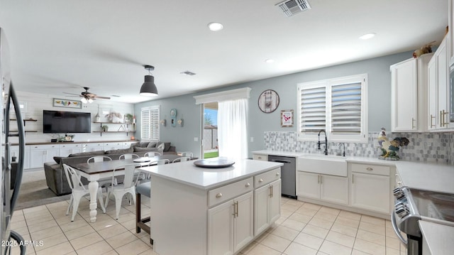 kitchen with sink, stainless steel appliances, backsplash, decorative light fixtures, and white cabinets