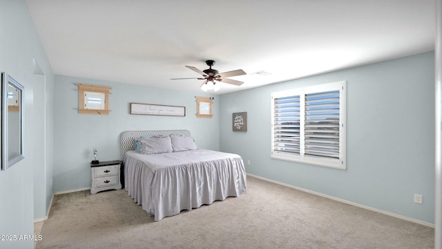 bedroom with multiple windows, ceiling fan, and light carpet