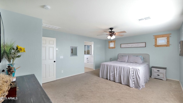 bedroom featuring connected bathroom, light colored carpet, and ceiling fan