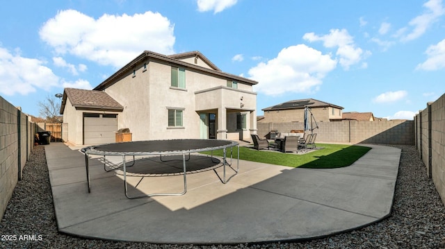 back of property featuring outdoor lounge area, a trampoline, a patio area, and a lawn