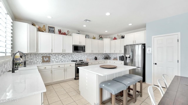 kitchen featuring a breakfast bar, sink, white cabinets, and stainless steel appliances